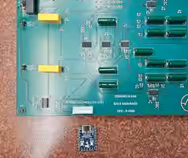 Bass Manager Rev A populated green PCB, with a loose blue RP2040-Zero controller board beside it